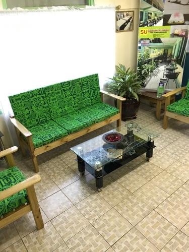 a living room with a green couch and a coffee table at Moatoga Hotel in Apia