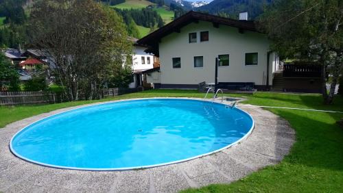 a large blue pool in front of a house at Appartement STOA in Kleinarl