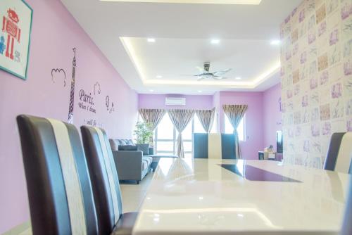 a dining room with purple walls and a table and chairs at Lavender One Residence Apartment in Sekincan