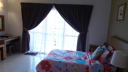 a bedroom with a bed and a large window at ZamLan Gold Coast Morib Intl Resort - Studio in Banting