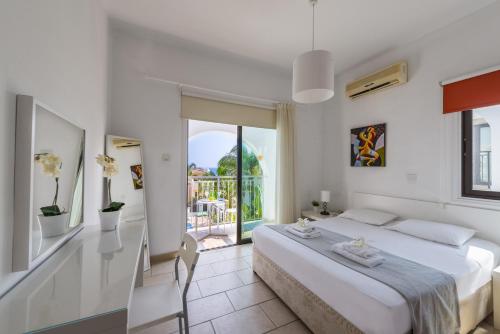 Biała sypialnia z łóżkiem i balkonem w obiekcie Protaras Holiday Villa Alexa w mieście Protaras