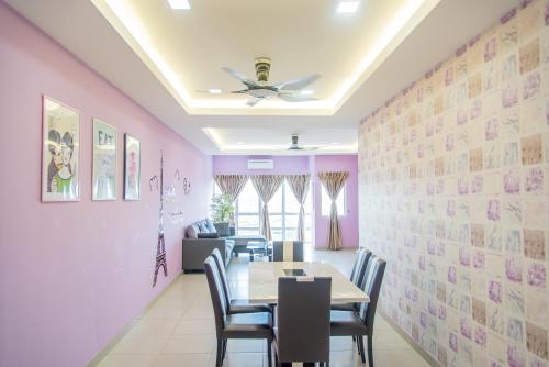 a dining room with pink walls and a table and chairs at Lavender One Residence Apartment in Sekincan