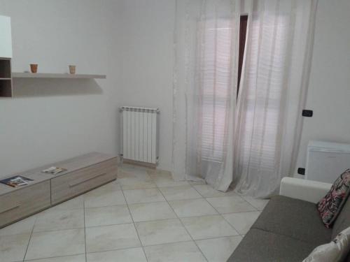 a white living room with a couch and a window at SWEET HOME GIULIA Locazione ad uso turistico in Cimitile
