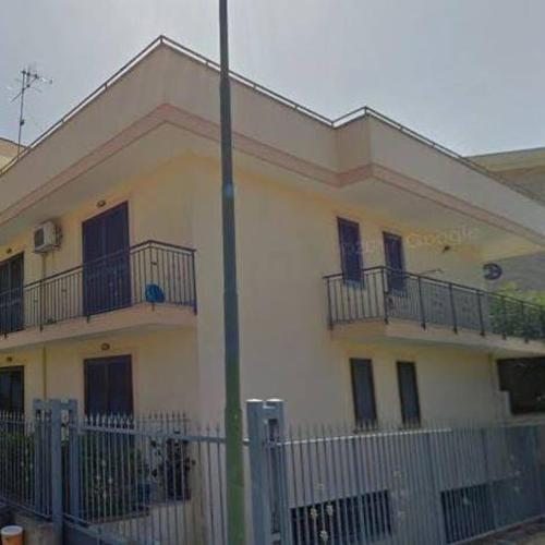 a white building with balconies and a fence at SWEET HOME GIULIA Locazione ad uso turistico in Cimitile