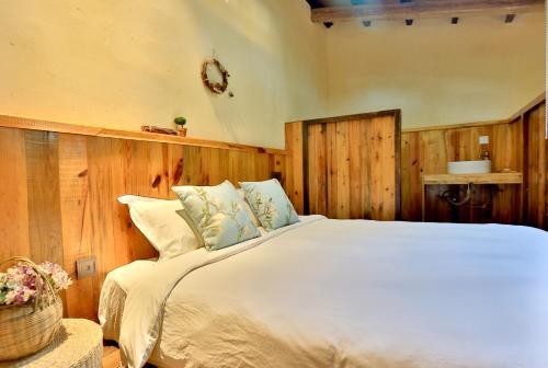 a bedroom with a large white bed with wooden walls at Youxiake Canal Hotel Hangzhou in Hangzhou