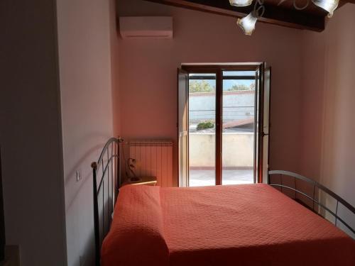 una camera da letto con un letto con copriletto rosso e una finestra di Borgo degli Amici a Faicchio