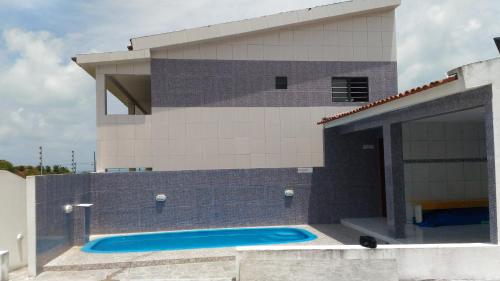 a house with a swimming pool in front of it at Sereia de Carapibus in Jacumã