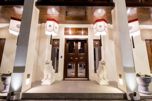 a front door of a house with two statues at Villa Lantara Chiangmai in Chiang Mai
