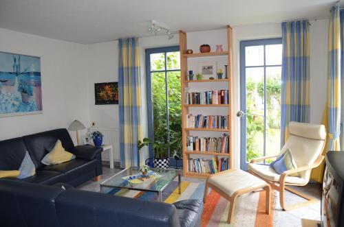 a living room with a couch and a book shelf at Inselresidenz Seeschwalbe Langeoog in Langeoog