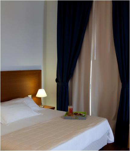 a bedroom with a bed with a tray of food on it at Hotel Tiziano in Trapani