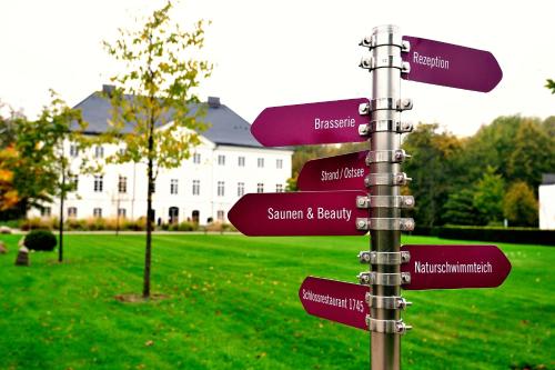 a pole with street signs in front of a building at Schlossgut Gross Schwansee in Groß Schwansee
