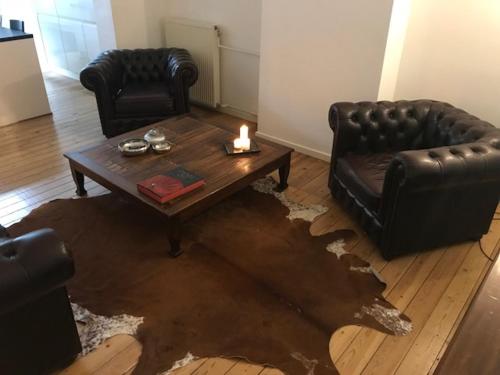 a living room with a couch and a table with a candle at Chic Cocoon Guest House in Brussels