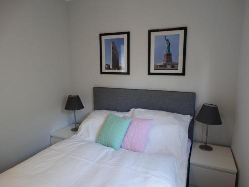 Dormitorio con cama blanca y almohada colorida en Ferienpark Vislust Haus Antje 1, en Wervershoof