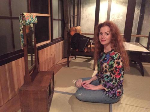 a woman sitting on the floor next to a mirror at YUMEJI Vintage Villa in Kyoto