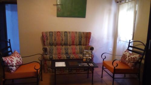 a living room with a couch and two chairs at Casa Rural "La Posada de María" in Malpartida de Cáceres