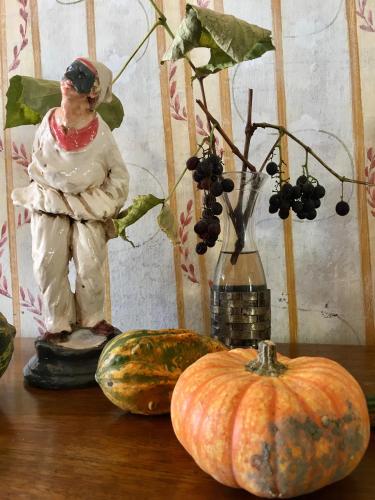 a table topped with pumpkins and a vase with a statue at Palazzo Suriano Heritage Hotel in Vietri sul Mare