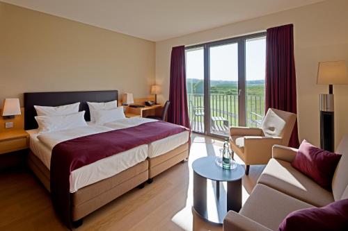 a hotel room with a bed and a balcony at Schlossgut Gross Schwansee in Groß Schwansee