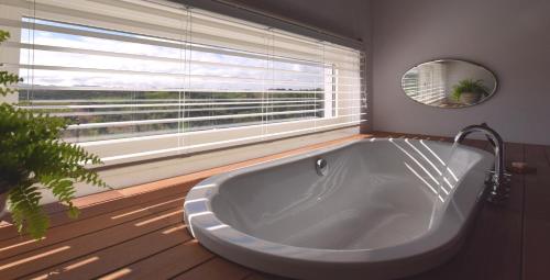 a large white tub in a bathroom with a window at Sernadinha in Aldeia do Cano