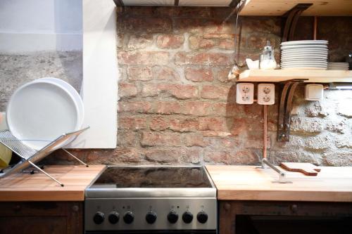 a kitchen with a stove and a brick wall at Giotto Apartments in Prague