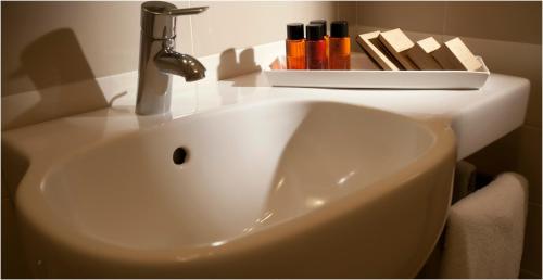 a white sink with a shelf on top of it at Hotel Tiziano in Trapani