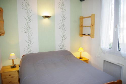 a bedroom with a bed and two lamps and a window at Maison à ROYAN PONTAILLAC in Royan
