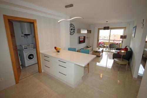 a kitchen with a white counter and a living room at LA PERLA by RENTMEDANO superb luxury duplex, private roof terrace, ocean view, pool, WiFi and parking in El Médano