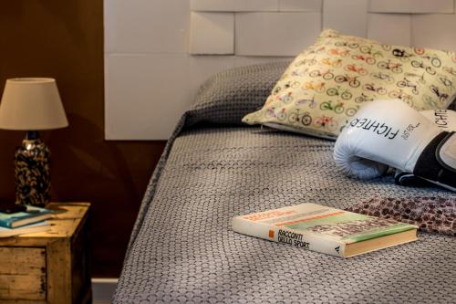 a book sitting on top of a bed with a lamp at Ad Hoc Rooms in Palermo