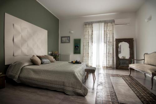 a bedroom with a bed and a chair at Ad Hoc Rooms in Palermo