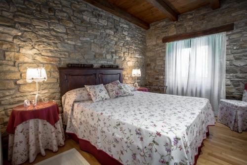 sypialnia z łóżkiem i kamienną ścianą w obiekcie Holiday Home Casa Dei Farfui w mieście Momjan