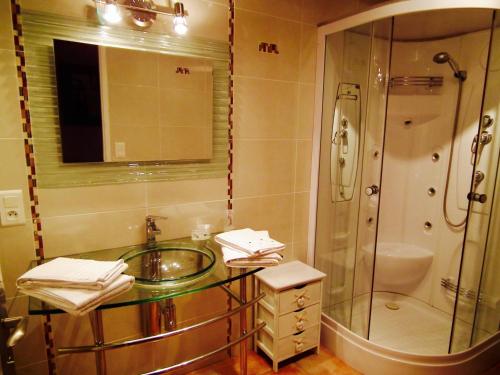 y baño con lavabo de cristal y ducha. en La Prade des "Pierre" en Mazamet