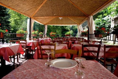 um restaurante com mesas e cadeiras com toalha de mesa vermelha em Borgo Isola Santa em Isola Santa