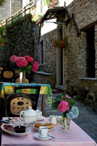 a table with a pink table cloth with food and flowers at Borgo Isola Santa in Isola Santa