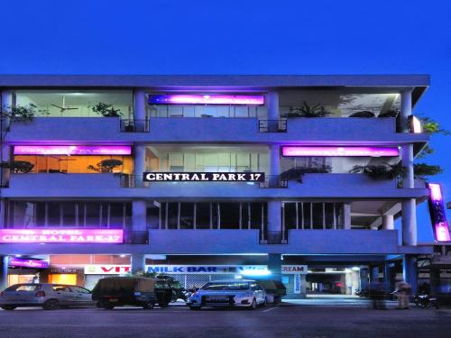 a blue building with cars parked in a parking lot at Hotel Central Park 17 in Chandīgarh