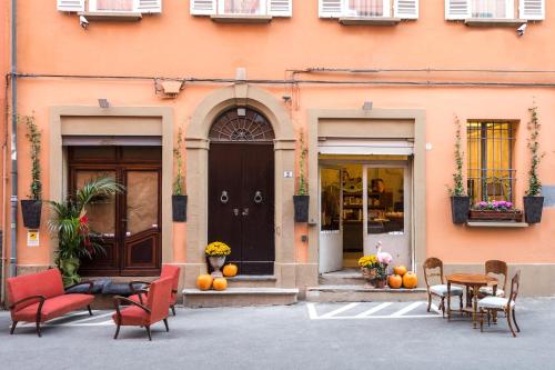 a building with chairs and tables in front of a door at L'8 Boutique Concept Apartments in Bologna