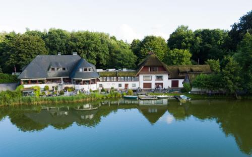 uma imagem de uma casa junto à água em Fischerklause am Lutjensee em Lütjensee