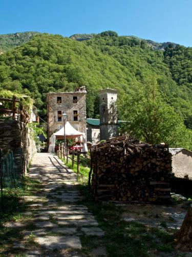 a stone building on a hill with a tent next to a road at Borgo Isola Santa in Isola Santa