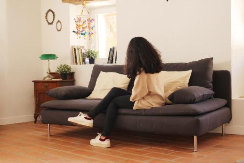 a woman sitting on a couch in a living room at La Grulla Dorada in Perales del Puerto