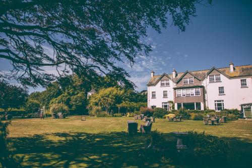 a large white house in a field with trees at Alexandra Hotel & Restaurant in Lyme Regis