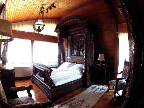 a bedroom with a large bed in a room with windows at Ferienhaus Waldblick in Sonnenbühl