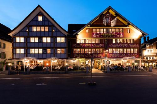 a large building with tables and chairs in front of it at Romantik Hotel Säntis in Appenzell