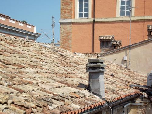 an old tile roof of a building next to a building at La casa di Oliva in Macerata