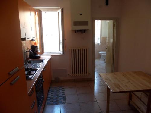 a kitchen with a stove and a sink and a table at La casa di Oliva in Macerata