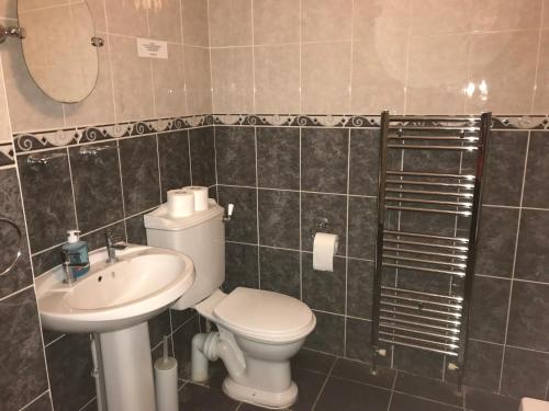 a bathroom with a toilet and a sink at The Coach House at The Bull Inn in Milton Keynes