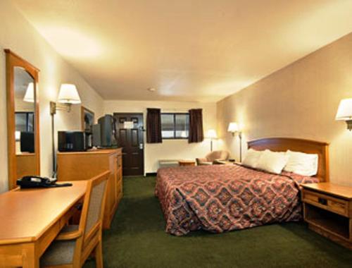 a hotel room with a bed and a desk at Travelodge by Wyndham Lemoore Near Naval Air Station in Lemoore