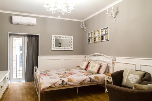 a bedroom with a bed and a chair at Amando Bucharest in Bucharest