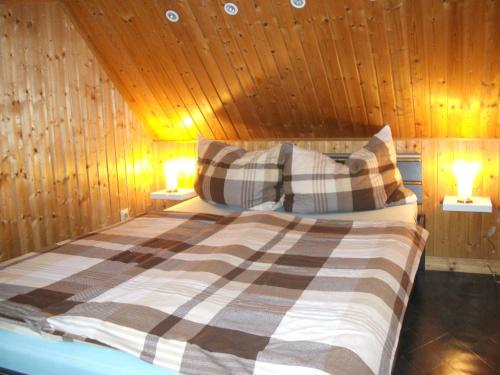 Kleine Ferienwohnung في بارث: غرفة نوم بسرير في جدار خشبي