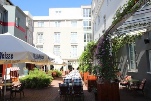 eine Terrasse mit Tischen und Stühlen und ein Gebäude in der Unterkunft Mercure Hotel Plaza Magdeburg in Magdeburg