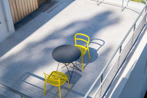 2 gelbe Stühle und ein Tisch auf einer Veranda in der Unterkunft Semeli in Kokkari