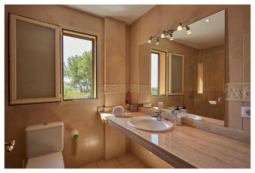 ein Badezimmer mit Waschbecken, Toilette und Spiegel in der Unterkunft Ca Ses Nines in Inca
