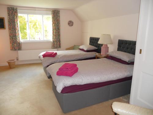 a bedroom with two beds with red towels on them at Mayertorne Cottage in Aylesbury